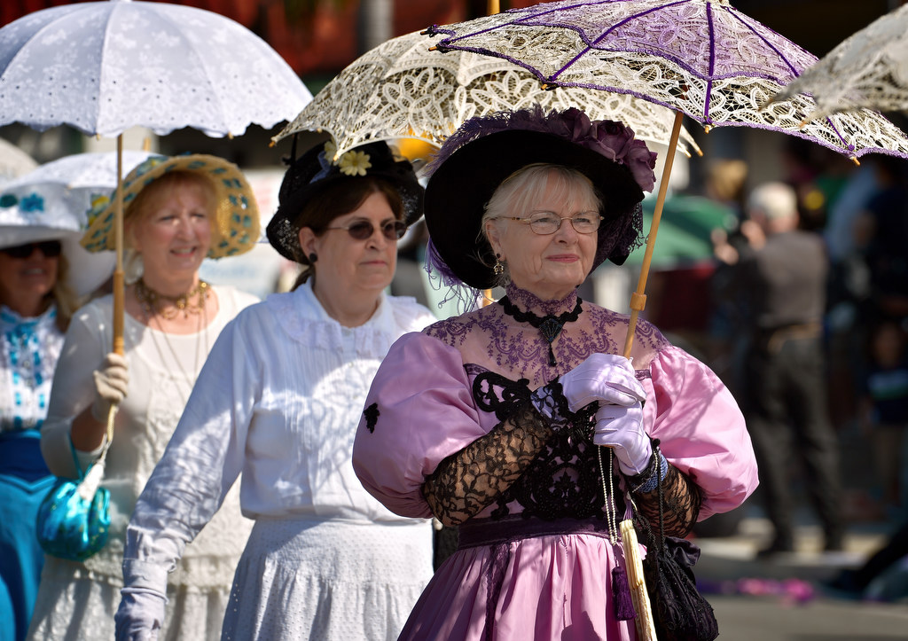 Women from the Fullerton Arboretum & Heritage House (there were men in the group too) walk down Harbor Blvd. in vintage clothes and umbrellas during the hot morning of the Founders Day Parade in Fullerton. Photo by Steven Georges/Behind the Badge OC