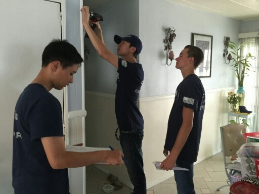 Explorers from the Cypress Police Department help install fire alarms at a family mobile home park in Cypress. More than 60 residents were given free smoke alarms as part of a program from the Orange County Fire Authority. Photo courtesy Cypress PD. 