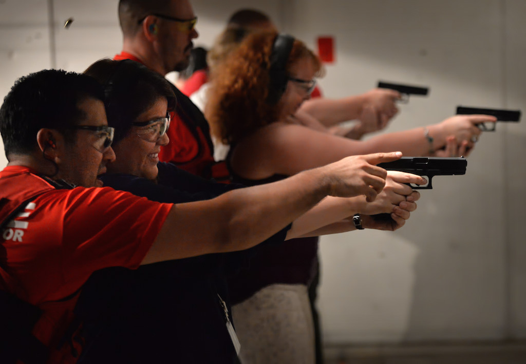 Alma Penalosa of Tustin gets first hand advice on firing a gun from Tustin PD Officer Mike Carter during Tustin PD Citizen's Academy class at Evans Shooters World Firing Range in Orange. Photo by Steven Georges/Behind the Badge OC