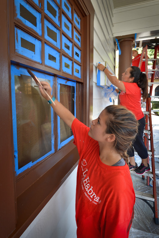 Alexie Blount, 16, of La Habra High, front, paints the windows of the Depot Playhouse Community Theatre in La Habra, also knows as the Mysterium Theatre, as Maria Delgado, another volunteer behind her, helps out during the city wide Love La Habra event. Photo by Steven Georges/Behind the Badge OC