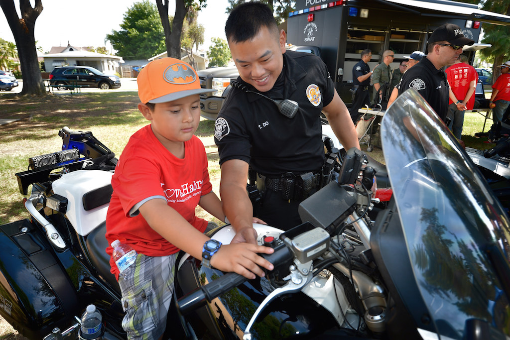 La Habra Officer Tam Do describes first hand the various buttons and controls on a police motorcycle during a picnic gathering for the Love La Habra event at Portola Park. Photo by Steven Georges/Behind the Badge OC