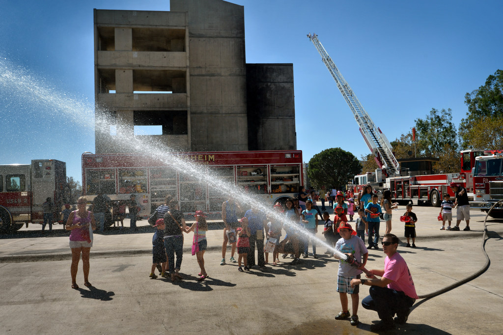 Eleven-year-old Diego Lomeli of Anaheim lets the water fly on a firehose with the assistance of Fullerton Firefighter Grant Castle during Fire Service Day at the North Net Training Center in Anaheim. Photo by Steven Georges/Behind the Badge OC