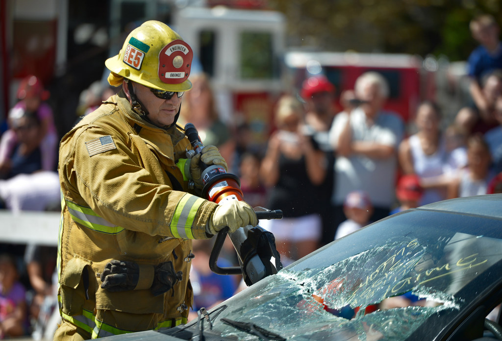 A firefighter engineer from the City of Orange demonstrate how to get to a victim trapped inside a crashed car using the Jaws of Life during Fire Service Day at the North Net Training Center in Anaheim. Photo by Steven Georges/Behind the Badge OC