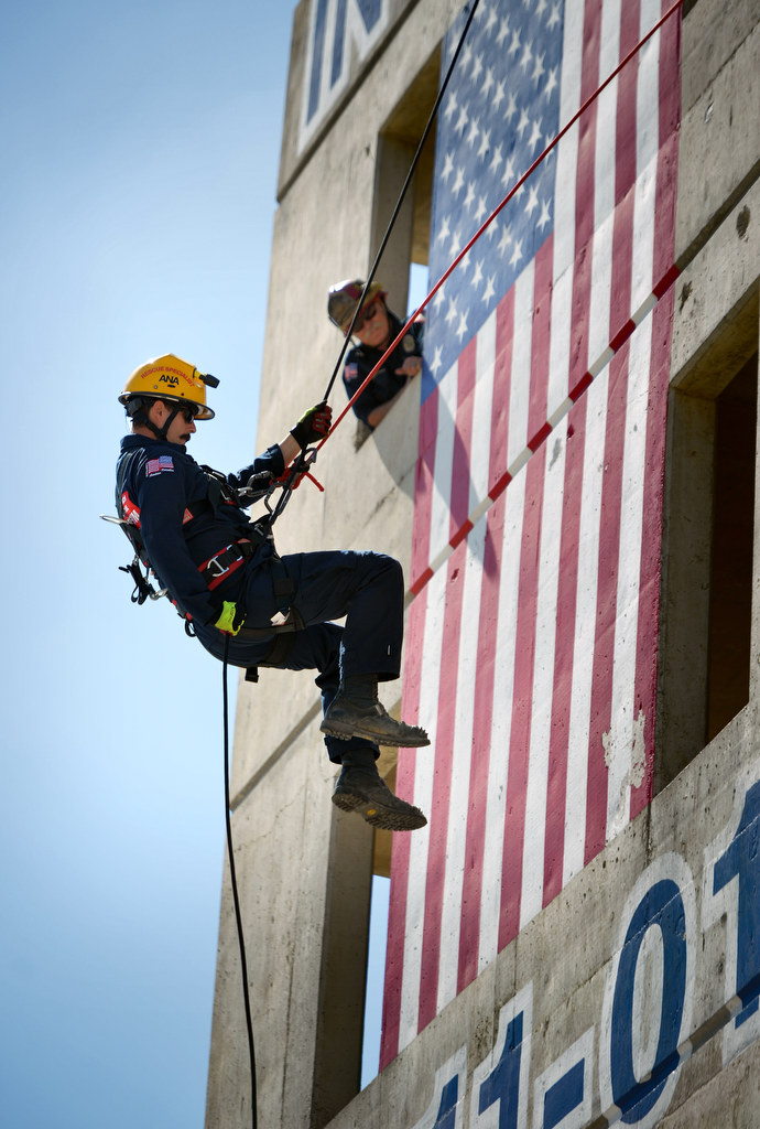 Engineer Aaron Hamblin of Anaheim Fire & Rescue’s US&R Team (Urban Search & Rescue) rappels down the training tower for the crowd gathered below during Fire Service Day at the North Net Training Center in Anaheim. Photo by Steven Georges/Behind the Badge OC