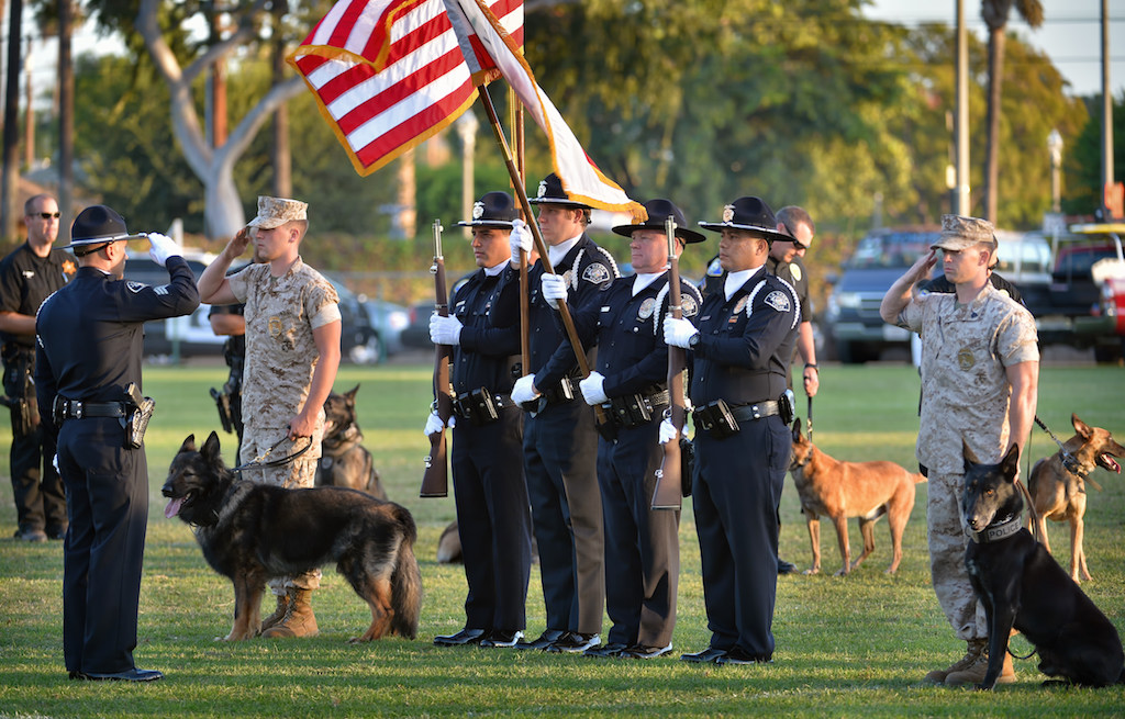 US Marines and the La Habra PD’s Color Guard stand at attention during the playing of the National Anthem at the start of the OCPCA’s 27th Annual Police K-9 Benefit Show at Glover Stadium in Anaheim. Photo by Steven Georges/Behind the Badge OC