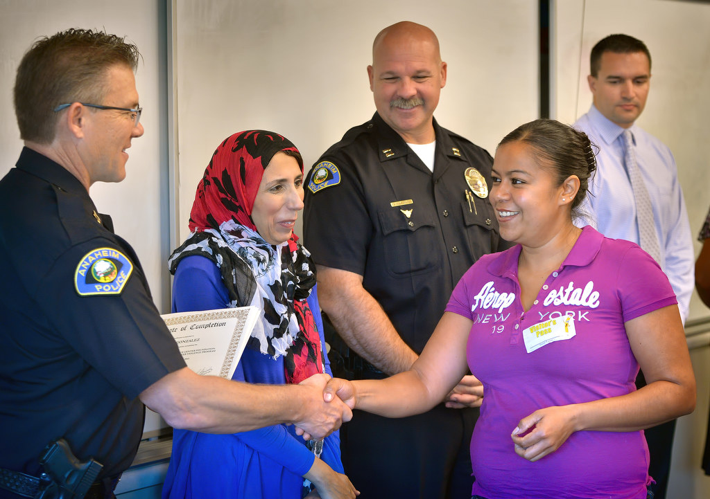 Anaheim PD Captan Eric Carter, left, congratulates Alicia Gonzalez as she receives her certificate from the Orange County Family Justice Center Foundation during a graduation ceremony. Photo by Steven Georges/Behind the Badge OC