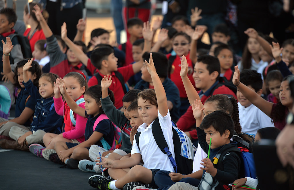 Kids from Estock Elementary School in Tustin raise their hands as they are asked how many have seen an auto accident in their lifetimes during a safety assembly led by the Tustin PD. Photo by Steven Georges/Behind the Badge OC