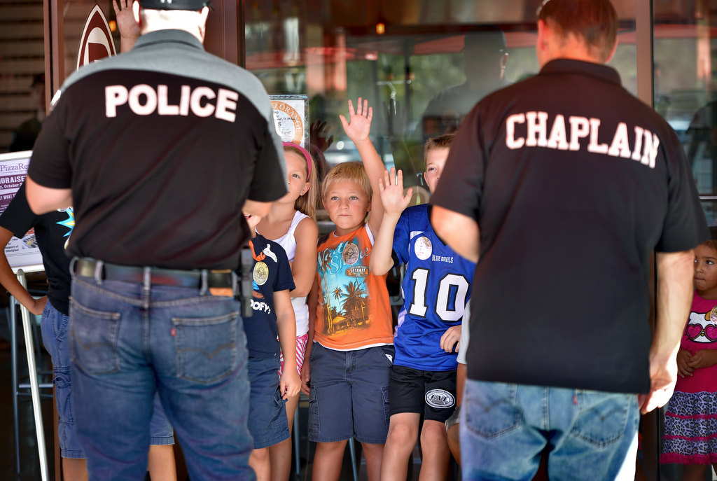 La Habra PD Officer Rob Sims, left, and La Habra PD Chaplain Mike Murphy talk to kids gathered at Pizza Rev in La Habra for the LHPD’s Pizza with a Police Pup as they answer questions about the La Habra’s police dogs. Photo by Steven Georges/Behind the Badge OC