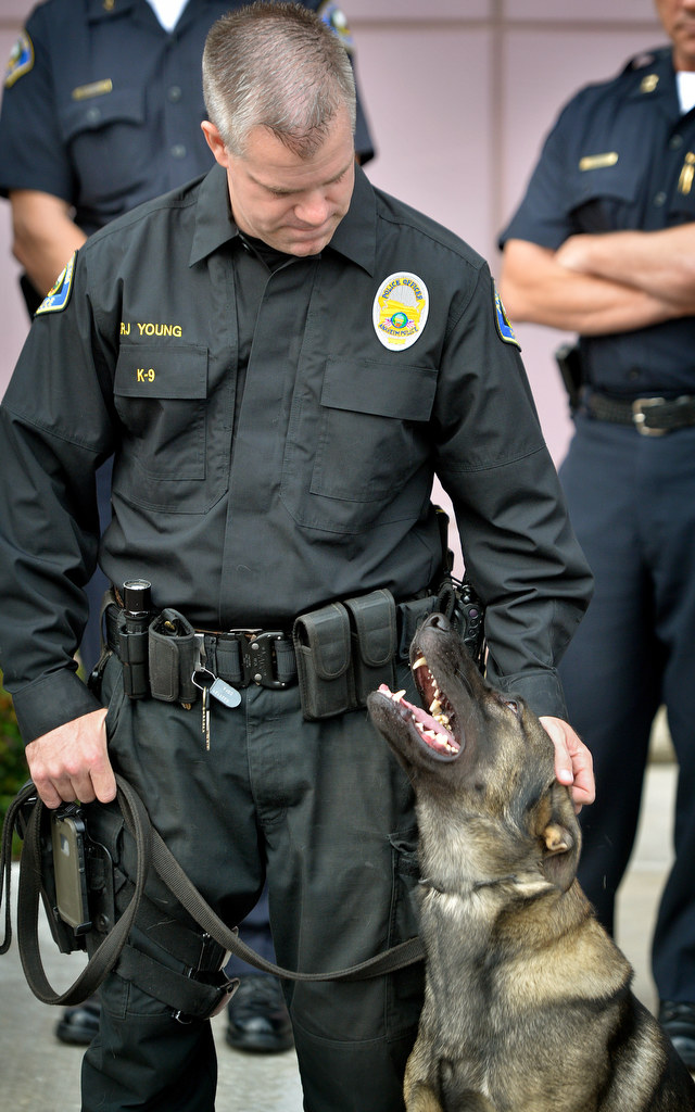 Anaheim Officer RJ Young gives his K-9 partner Yukon some positive affection during a K-9 memorial dedication at Anaheim PD’s East Sub Station. Photo by Steven Georges/Behind the Badge OC