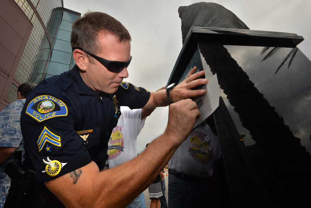 Anaheim PD Officer Jeff Burke sketches the name “Rony” from the Anaheim Police Service Dog Memorial after a dedication ceremony at the Anaheim PD East Sub Station. Photo by Steven Georges/Behind the Badge OC