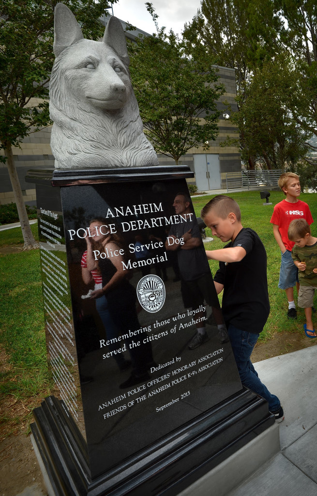 Ten-year-old Ethan Sutter sketches his dad’s, Anaheim PD K-9 Officer Matt Sutter, old dog’s name, “Recon,’ on paper after a dedication ceremony for the new police K-9 memorial at Anaheim PD’s East Sub Station. Photo by Steven Georges/Behind the Badge OC