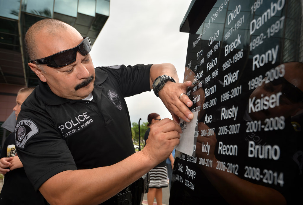 Officer Jesse Romero sketches the name “Luke” from the Anaheim Police Service Dog Memorial after a dedication ceremony at the Anaheim PD East Sub Station. Photo by Steven Georges/Behind the Badge OC