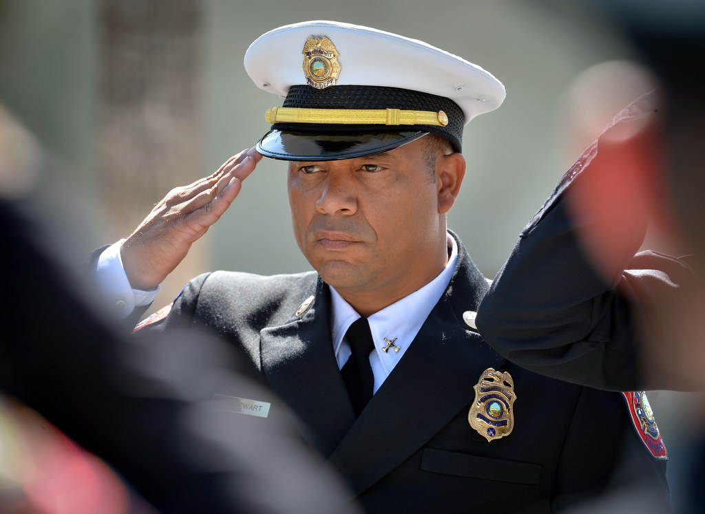 Battalion Chief Kevin Stewart, of Anaheim Fire & Rescue, salutes as the casket containing Metro Net Dispatcher John Delgado is carried out of the La Purisima Catholic Church in Orange after a memorial service. Photo by Steven Georges/Behind the Badge OC