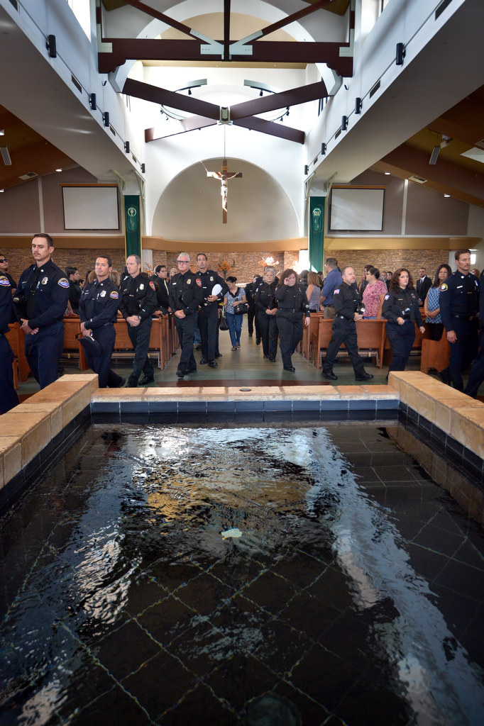 Firefighters file out of the La Purisima Catholic Church in Orange past the indoor water fountain at the conclusion of memorial services for Metro Net Dispatcher John Delgado. Photo by Steven Georges/Behind the Badge OC