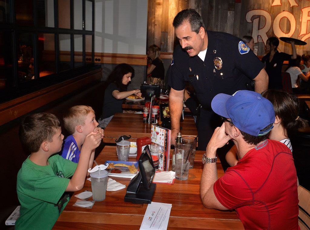 Garden Grove PD Captain Ben Stauffer talks to Reid Sturgeon, left, and his brother Nathan Sturgeon of Saskatchewan Canada during the Tip a Cop fundraiser for Special Olympics at Red Robin Restaurant in Garden Grove. Photo by Steven Georges/Behind the Badge OC