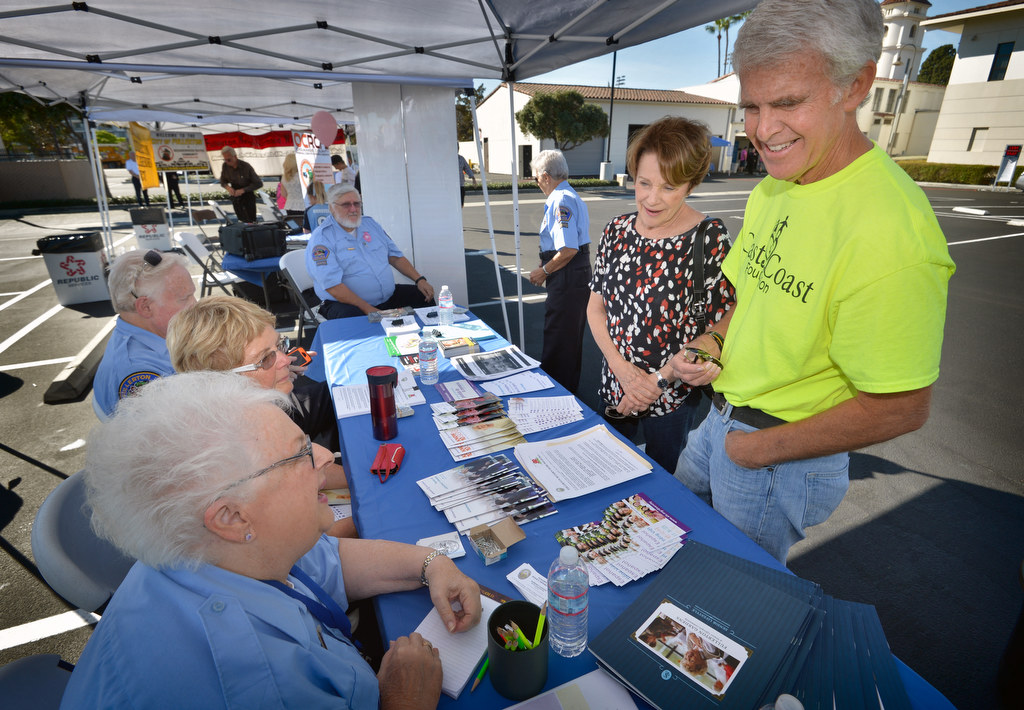 Barbara Giasone, a senior volunteer with the Fullerton PD, left, talks to Marti Rhode and her husband Dave Rhode of Fullerton about the Fullerton Return Home Registry and other issues related to those who care for seniors, during Fullerton PD’s Fourth Annual Police Department Open House. Photo by Steven Georges/Behind the Badge OC
