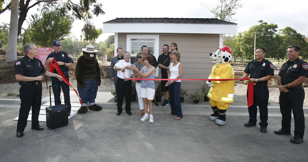 Anaheim Fire Chief Randy Bruegman, left, oversees the ribbon cutting for the department's fire safe house at the  Ready, Set, Go Block Party.  Photo by Christine Cotter/Behind the Badge OC