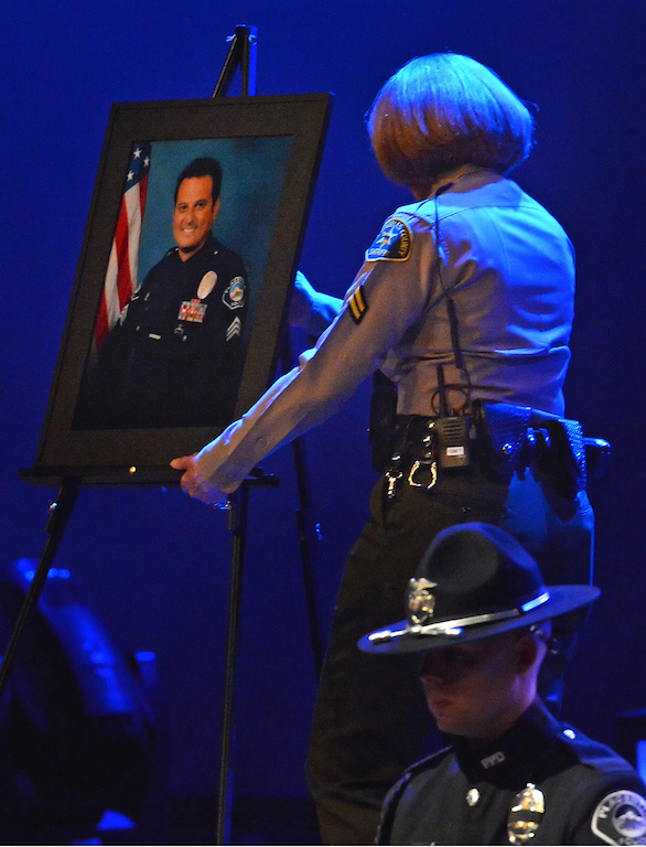 A Los Angeles Sheriff's Department deputy moves a picture of Lt. Kenneth Alexander of the Placentia Police Department to prepare for a slide show during a memorial service for Alexander last year. Photo by Steven Georges/Behind the Badge OC