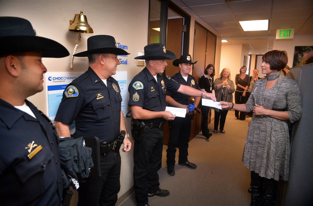 Sgt. Rodney Duckwitz presents a donated check to Monique Bates, manager community relations for CHOC ChildrenÕs Foundation, at CHOC Hospital in Orange. Photo by Steven Georges/Behind the Badge OC