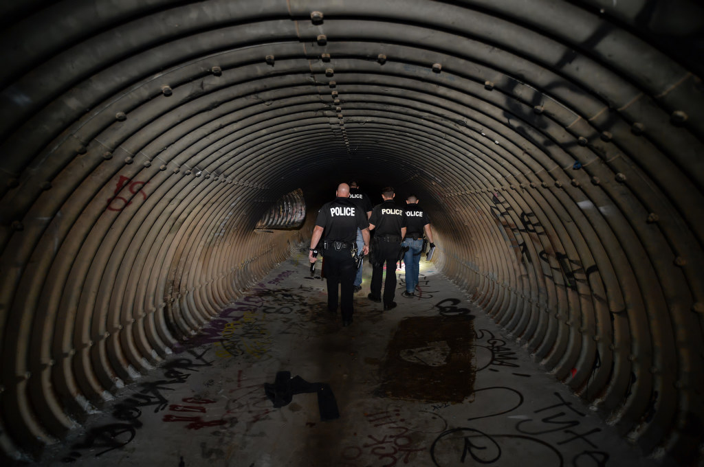 Officers from Fullerton PD and La Habra PD walk through flood control tunnels near Harbor Blvd. and Imperial Hwy. looking for homeless people that might be living there, which would be dangerous should it rain. Photo by Steven Georges/Behind the Badge OC