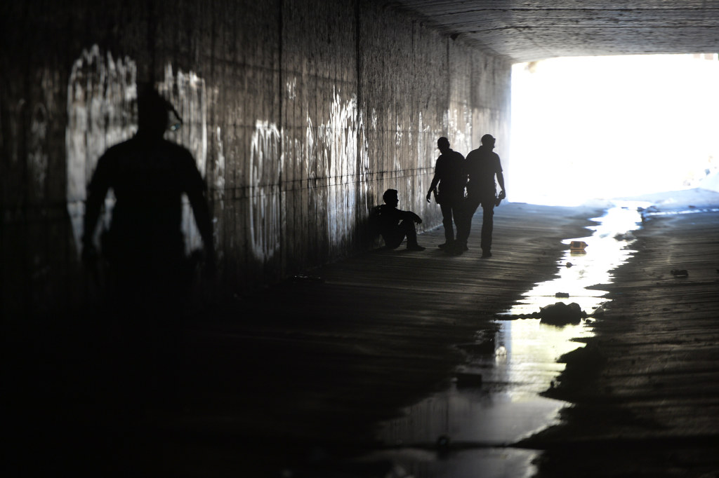La Habra PD and Fullerton PD officers talk to a man (sitting) in one of the flood control tunnels near Beach Blvd. and Imperial Hwy. Photo by Steven Georges/Behind the Badge OC