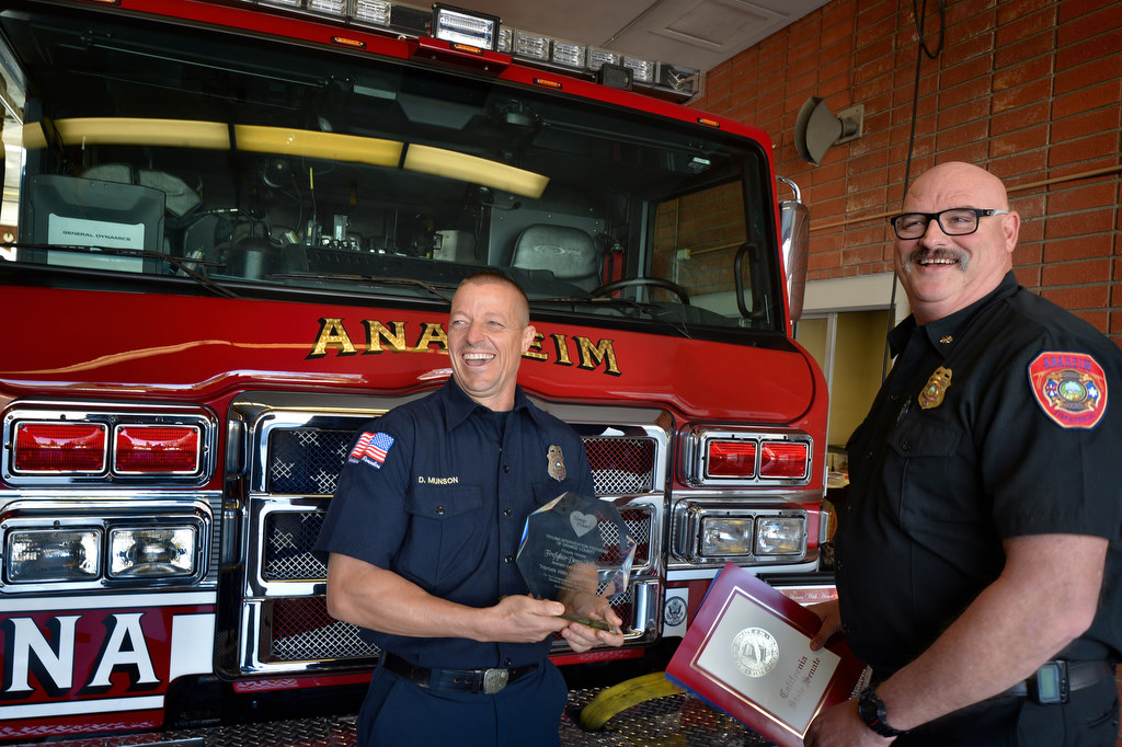 Anaheim Fire & Rescue Firefighter Denny Munson of Anaheim Fire Station 1, left, receives the TIP award from Deputy Chief Pat Russell during a small ceremony at station 1. Munson was unable to attend the annual Heroes with Heart awards dinner. Photo by Steven Georges/Behind the Badge OC