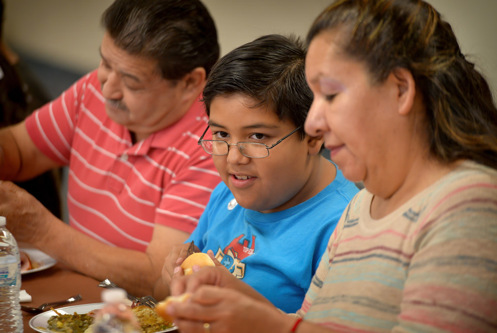 Juan Ugalde, 11, eats a turkey dinner with his parents, Simon and Silvia, during a GRIP gathering at Topaz Elementary in Fullerton to honor GRIP students. Photo by Steven Georges/Behind the Badge OC