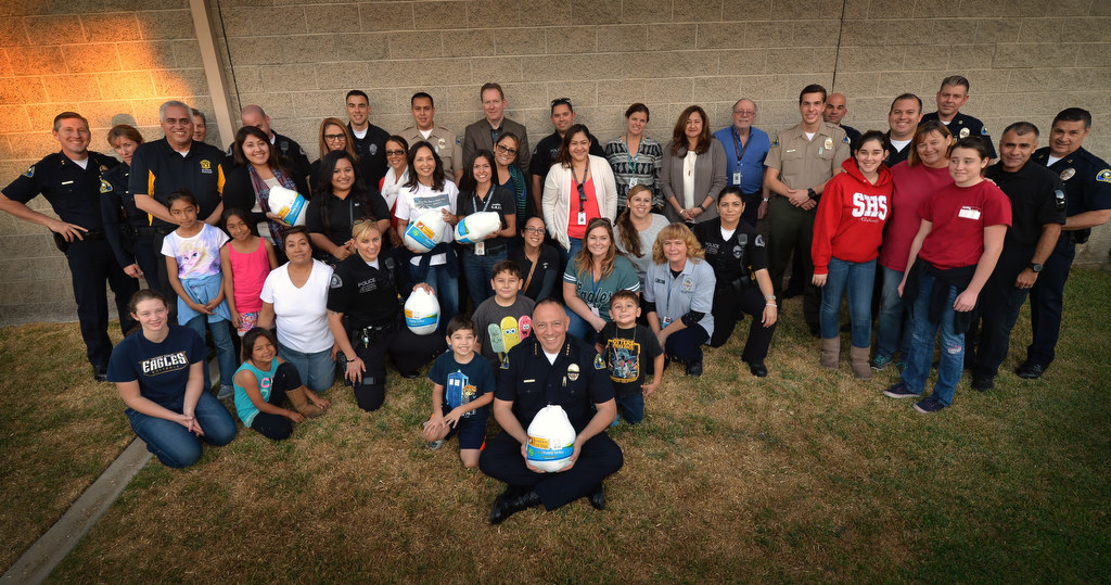 Anaheim GRIP (Gang Reduction Intervention Partnership) and Anaheim PD join the Chief’s Advisory Board and the Chief’s Neighborhood Advisory Council for a group photo before delivering Thanksgiving meals to GRIP students who earned it for their family. Photo by Steven Georges/Behind the Badge OC