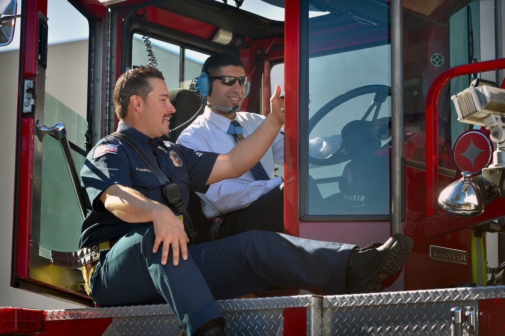 Firefighter Mike Houghton gives Medal of Honor Recipient Captain Florent Groberg instructions on how to operate the rear of a firetruck from inside the tiller bucket during a tour of Anaheim Fire Station 3. Photo by Steven Georges/Behind the Badge OC