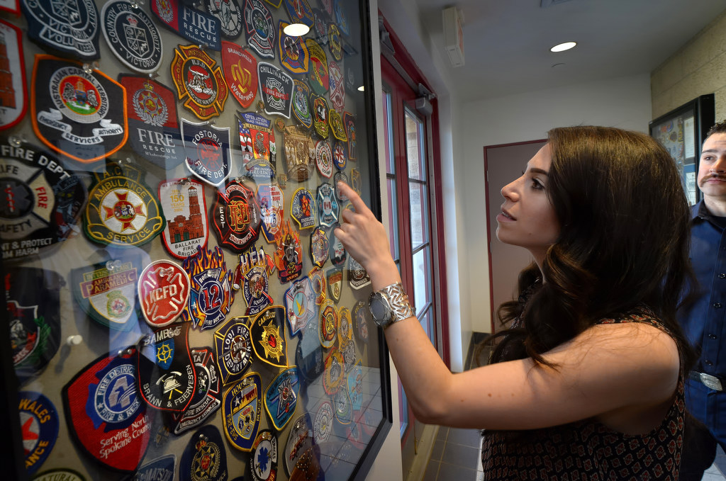 Carsen Zarin, girlfriend of Medal of Honor recipient Florent Groberg, takes a closer look at the fire patches on display from across the country and around the world during a tour of Anaheim Fire Station 3. Photo by Steven Georges/Behind the Badge OC