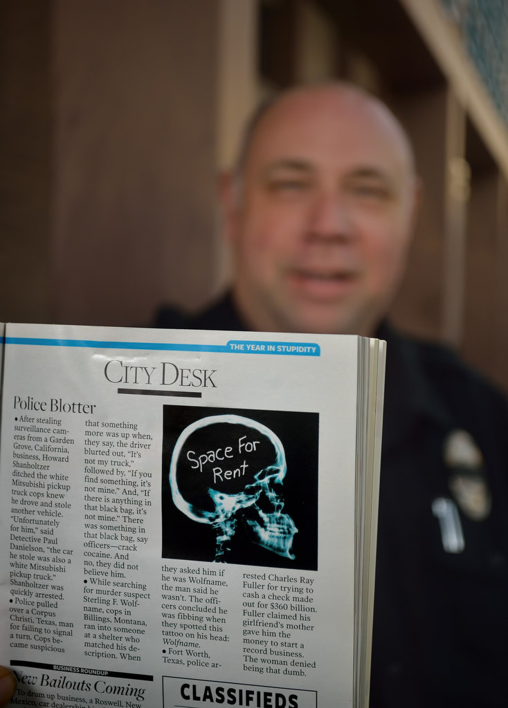 Garden Grove Master Reserve Officer Paul Danielson holds up a Reader’s Digest from 2009 that contains a dumb criminals story, back when Officer Danielson was a detective, about a suspect who tried to avoid police by stealing a car that was the exact make and color as the pickup he was trying to hide, and then moved his license plate to the new car. Jay Leno also featured the story on "The Tonight Show." Photo by Steven Georges/Behind the Badge OC