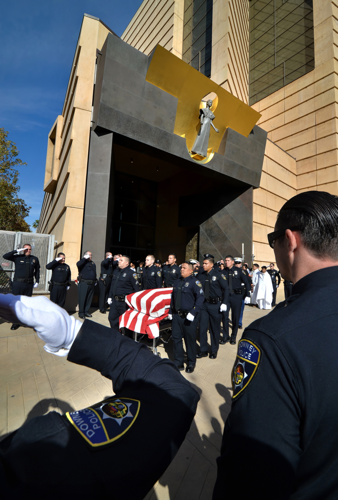Officers stand and salute as Downey police pallbearers carry out the casket of Downey PD Officer Ricardo "Ricky" Galvez at the conclusion of funeral services at the Cathedral of Our Lady of the Angels. Photo by Steven Georges/Behind the Badge OC