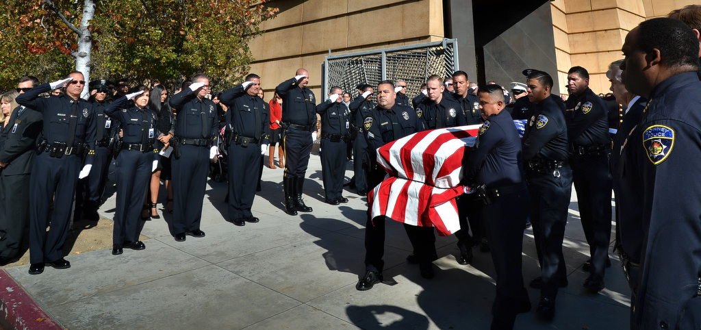Officers stand and salute as Downey police pallbearers carry out the casket of Downey PD Officer Ricardo "Ricky" Galvez at the conclusion of funeral services at the Cathedral of Our Lady of the Angels. Photo by Steven Georges/Behind the Badge OC