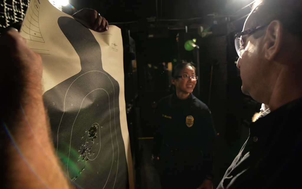 Officer Michael Reynolds, range master for GGPD, right, goes over the results on a target from Susan Huang at a local mobil shooting range used by the police. Photo by Steven Georges/Behind the Badge OC