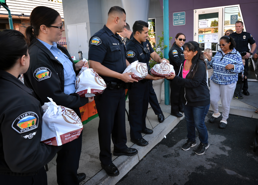 Jolanda Mendoza of Tustin receives a free turkey from the Tustin PD the day before Thanksgiving at the Tustin Family & Youth Center. Photo by Steven Georges/Behind the Badge OC