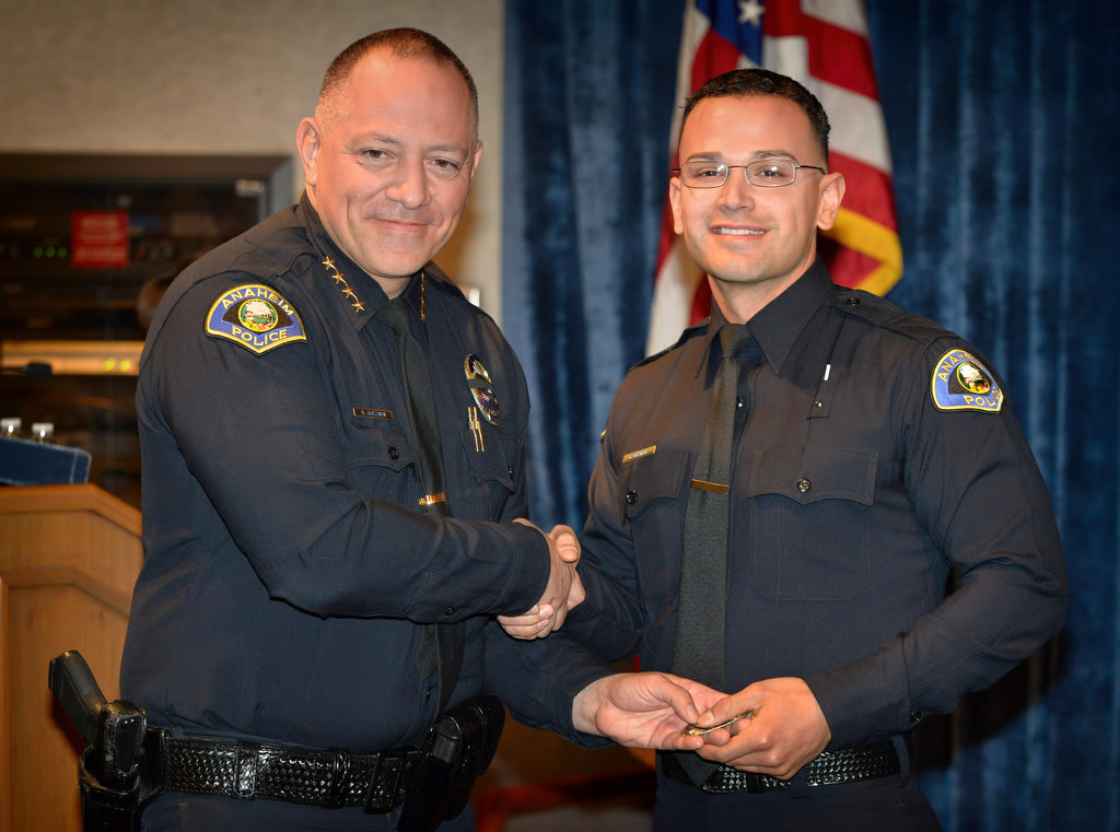 Anaheim Police Chief Raul Quezada, left, presents Ruben Guzman with his new badge as he joins the Anaheim PD during a ceremony. Photo by Steven Georges/Behind the Badge OC