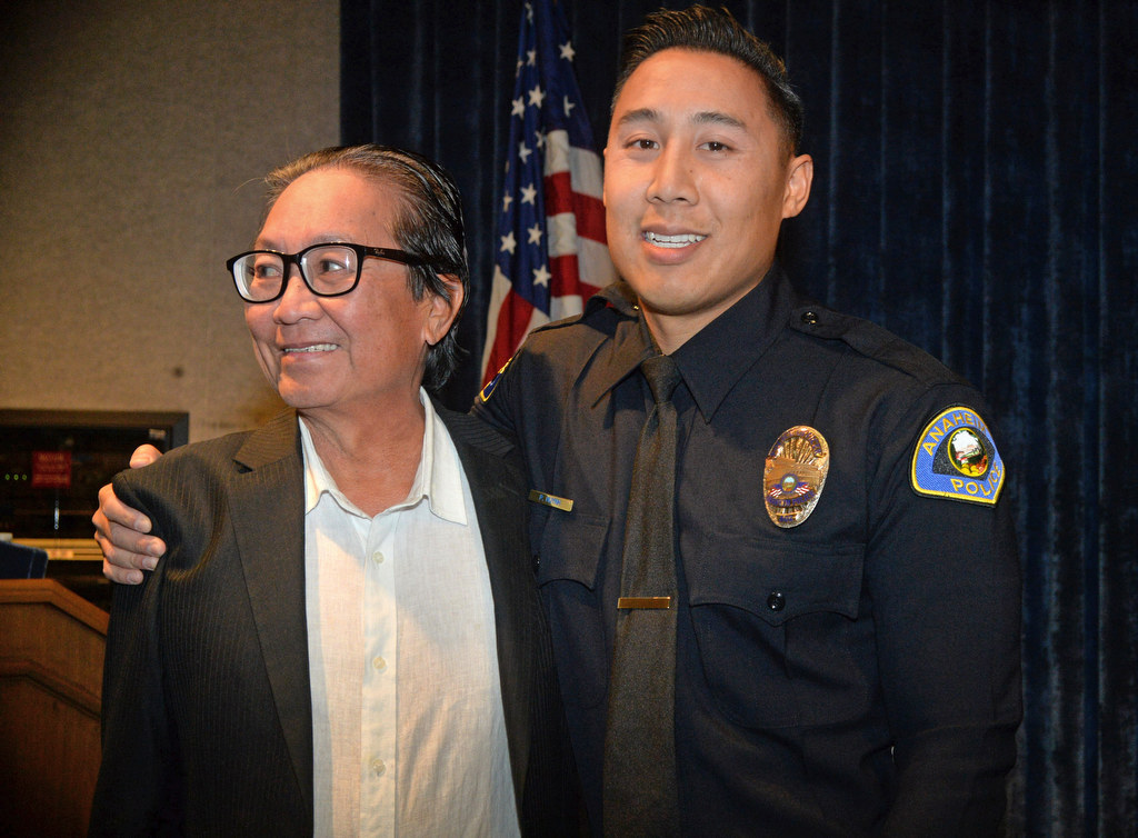 Anaheim PD’s new officer, Phillippe Huynh, gives his father, Allan Huynh, a hug after receiving his new badge as an Anaheim PD officer. Photo by Steven Georges/Behind the Badge OC
