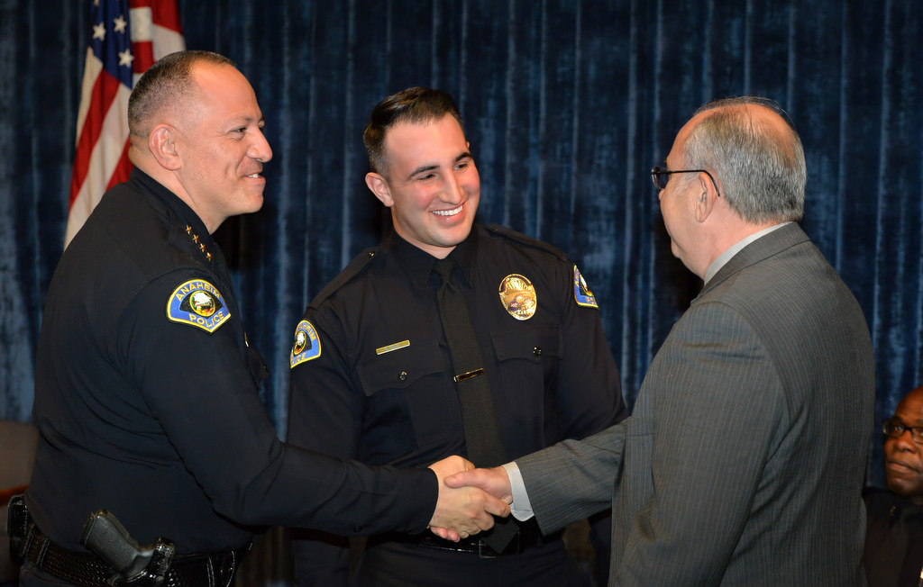 Sam Silva, a retired Lieutenant from the Los Angeles County Sheriff’s Department, right, is congratulated by Anaheim Police Chief Raul Quezada after Silva’s son Samuel Silva, center, received his new Anaheim PD badge. Photo by Steven Georges/Behind the Badge OC