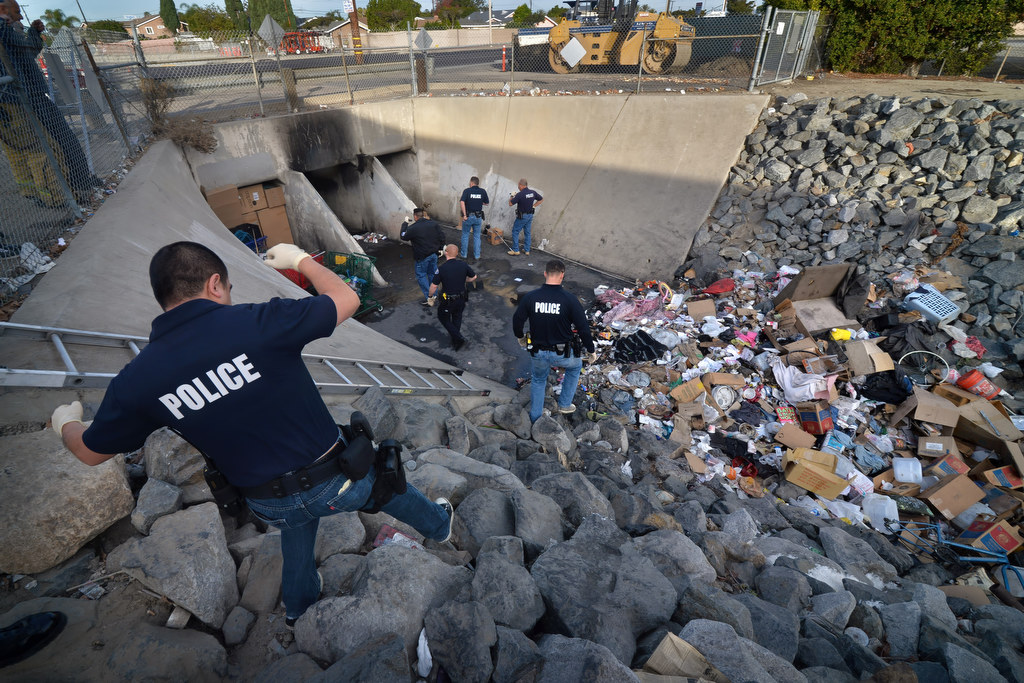 Garden Grove police make their way down the rocks leading to the storm drain under Brookhurst St. where homeless and drug users were living. Photo by Steven Georges/Behind the Badge OC