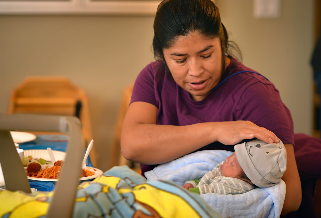 Maria Ramerez of Hesperia tends to her 3-week-old son David as she enjoys a spaghetti dinner prepared by youths from Community Service Programs’ (CSP) Juvenile Diversion at the Ronald McDonald House in Orange. Photo by Steven Georges/Behind the Badge OC