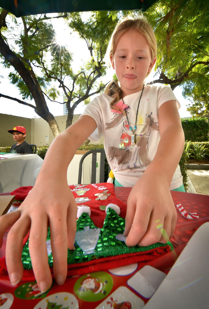 Eight-year-old Tate Nicholson of Newport Beach decorates Christmas stockings to be donated to the less fortunate as HomeAid Orange County volunteers assemble care kits. Photo by Steven Georges/Behind the Badge OC