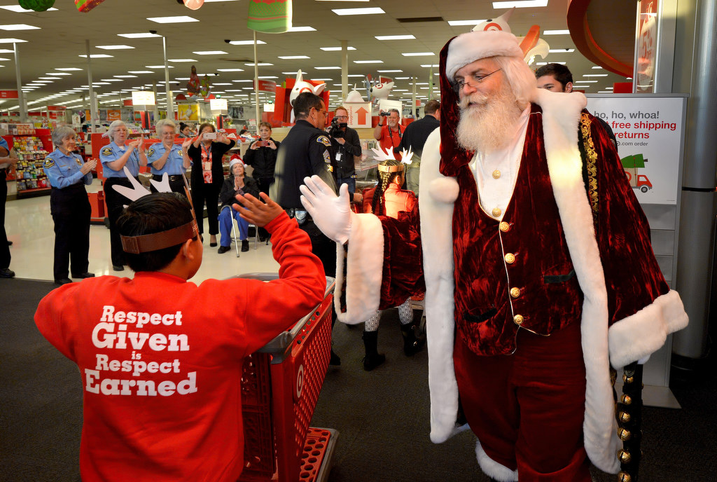 Santa gives kids high-fives as they enter the Target store for Anaheim PD’s annual Shop With a Cop event. Photo by Steven Georges/Behind the Badge OC