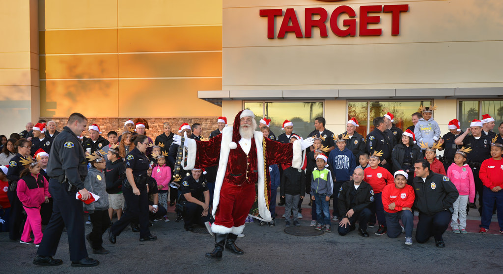 Santa joins in the fun as Anaheim PD officers and kids gather for a group photo in front of the Target store in Anaheim for the annual Shop With a Cop event. Photo by Steven Georges/Behind the Badge OC