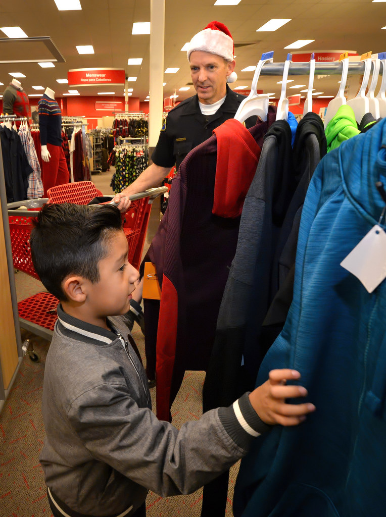 Adam Arreola, 7, looks for clothes with Anaheim PD Officer Gerry Verpooten during Anaheim PDÕs Shop With a Cop event at a local Target store. Photo by Steven Georges/Behind the Badge OC