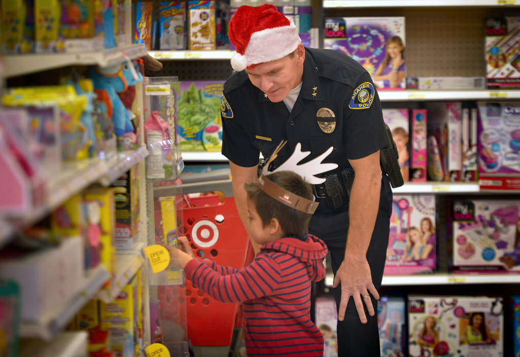 Anaheim PD Deputy Chief Julian Harvey helps Jesus Sease, 5, pick out what he wants in the toy section of Target during Anaheim PD’s annual Shop With a Cop. Photo by Steven Georges/Behind the Badge OC