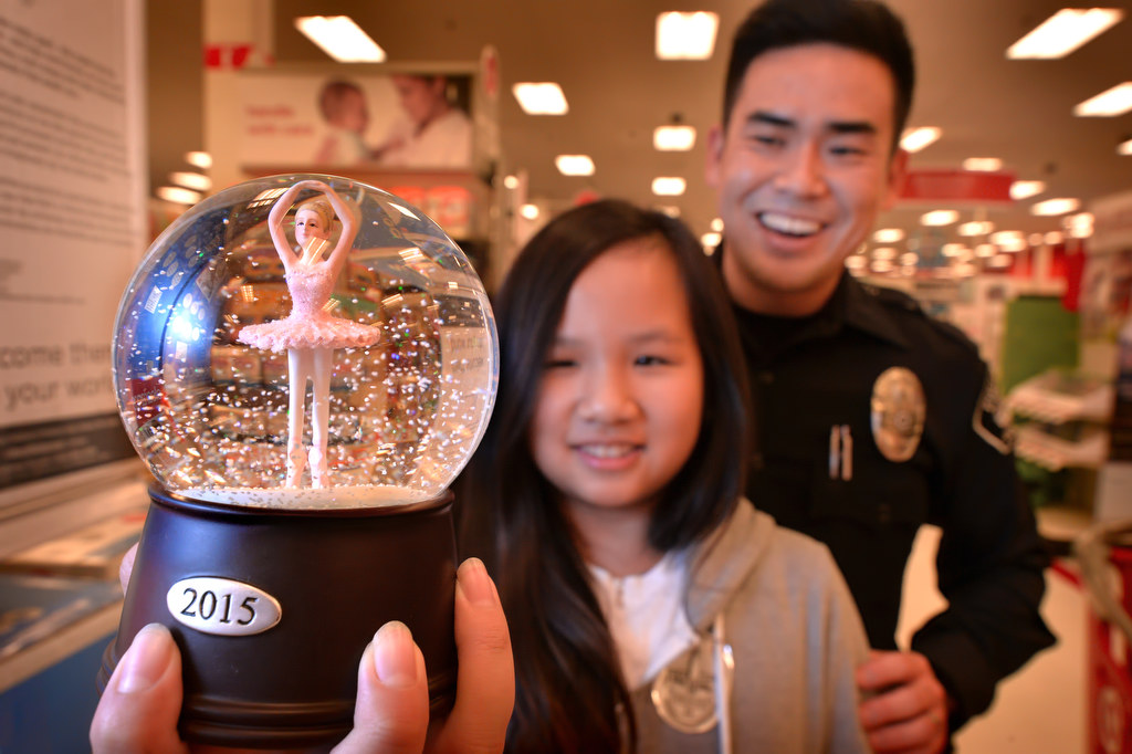 Brianna Tran, 11, holds a ballerina snow globe she is getting for a friend with the help of Fullerton PD Officer Michael Yang during Fullerton PD’s Shop With a Cop at a local Target store. Photo by Steven Georges/Behind the Badge OC