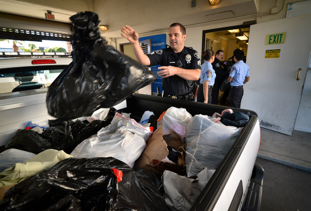 Fullerton PD Sgt. John Ema helps load donated clothes into the back of a pickup truck at Fullerton Police headquarters to be taken to the drop off point for Clothes For The Cause, a fundraiser in part for 6-year-old Katherine King who suffers from an incurable brain stem tumor. Photo by Steven Georges/Behind the Badge OC