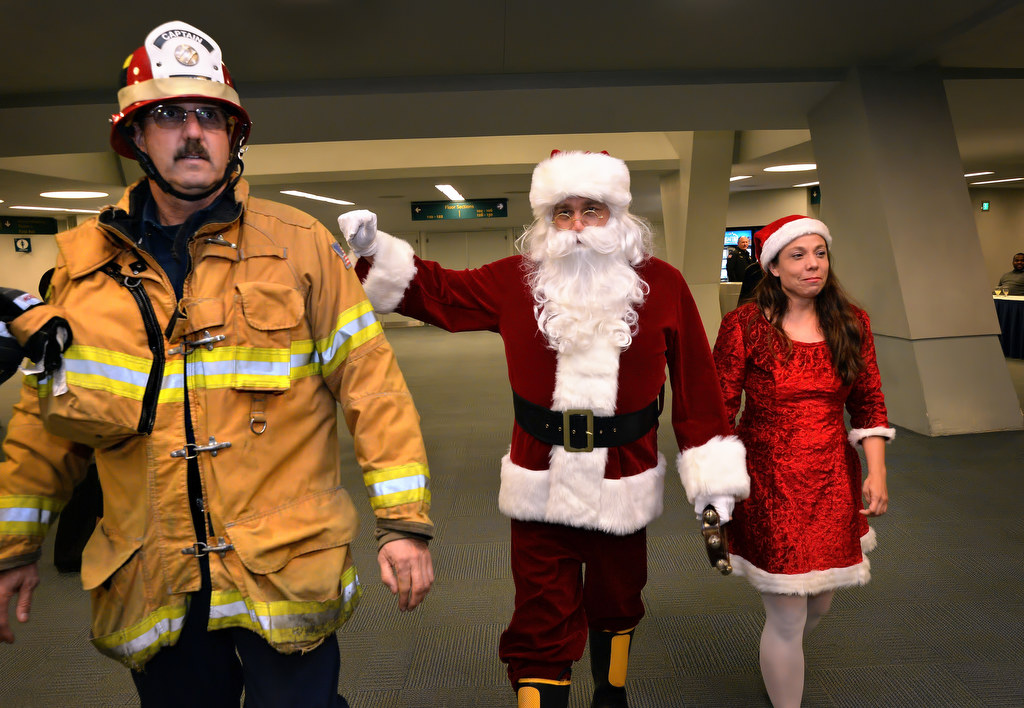 Captain Scott Fox, a paramedic with Anaheim Fire & Rescue, helps escort Santa and Mrs. Claus to the Burn Survivor’s Santa Jamboree at the Anaheim Convention Center. Photo by Steven Georges/Behind the Badge OC