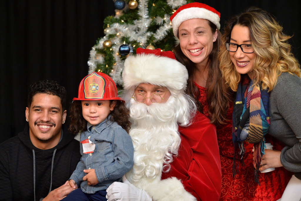 Two year-old Makai Ewing visits Santa and Mrs. Claus with his parents Marcus Ewing, left, and Alyssa Ewing during the Burn Survivor’s Santa Jamboree at the Anaheim Convention Center put on by the UC Irvine Health Regional Burn Center and Anaheim Fire & Rescue. Photo by Steven Georges/Behind the Badge OC