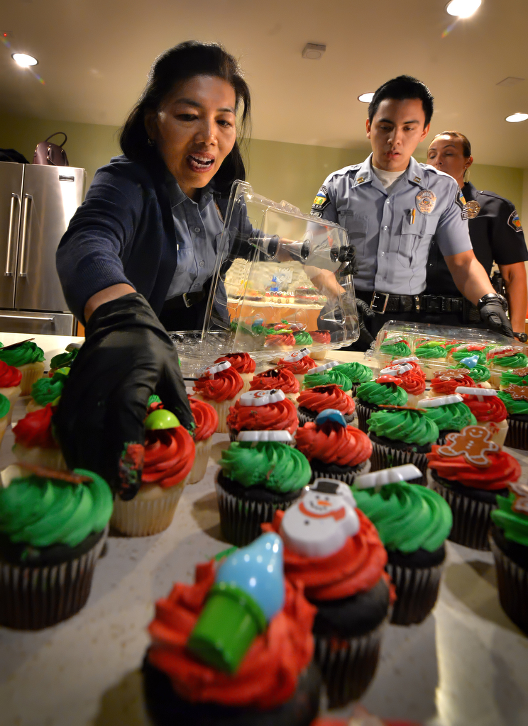 Tustin PD Volunteer Lili Golden places holiday cupcakes for the families attending Tustin PD’s annual “Santa Cop” at the Tustin Community Center. Photo by Steven Georges/Behind the Badge OC